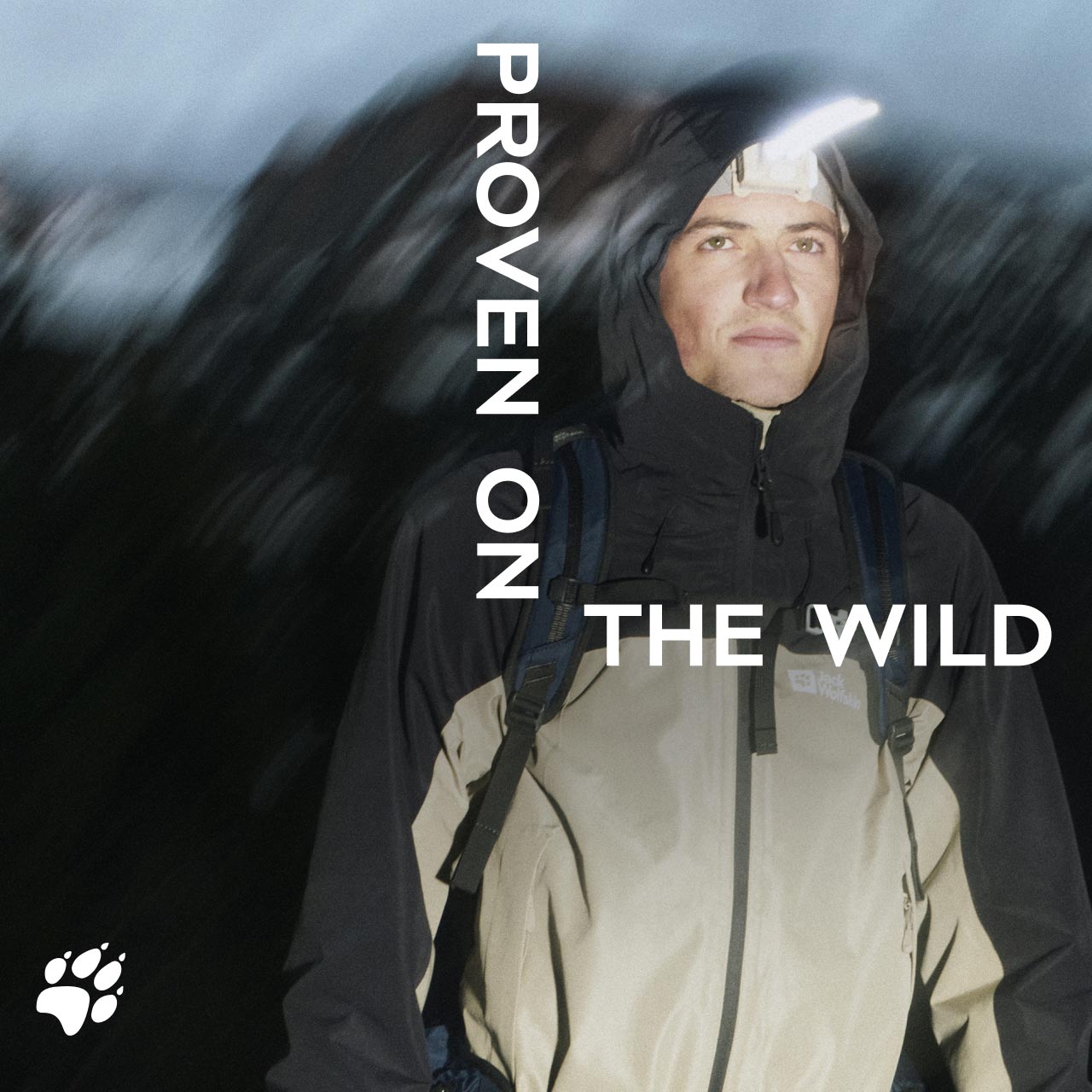 A person in a hooded jacket stands outdoors at night, wearing a headlamp. Text reads "Proven on the Wild"